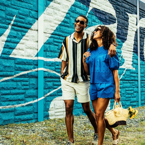 A beautiful community at the heart of all your passions two people waking next to a mural