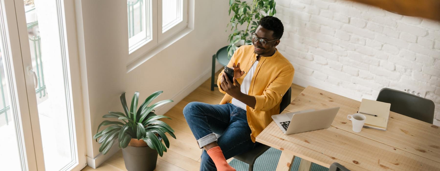 a person sitting at a table with a laptop and a camera